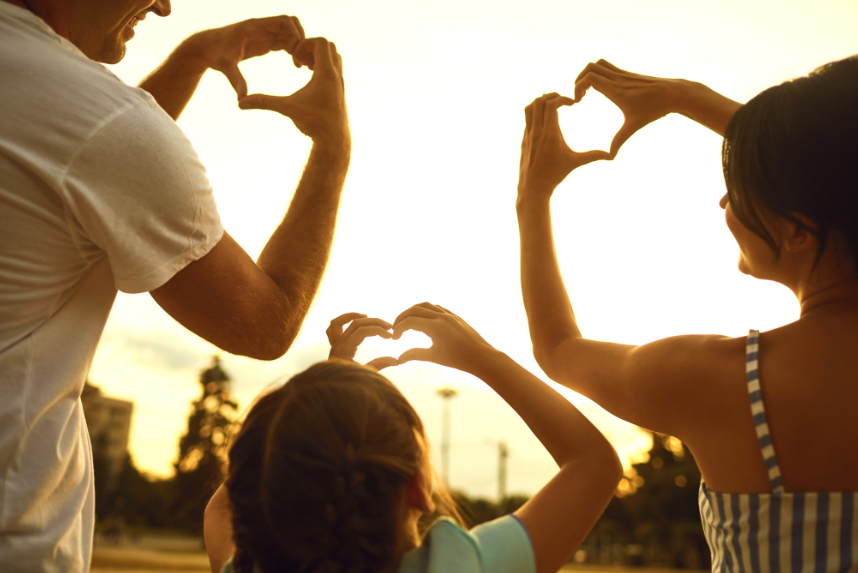 family making heart shapes with hands to symbolise love