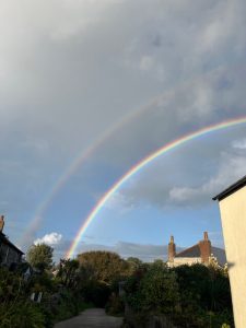 A soft rainbow stretching over the Cornish coastline, blending light and rain in a moment of calm.