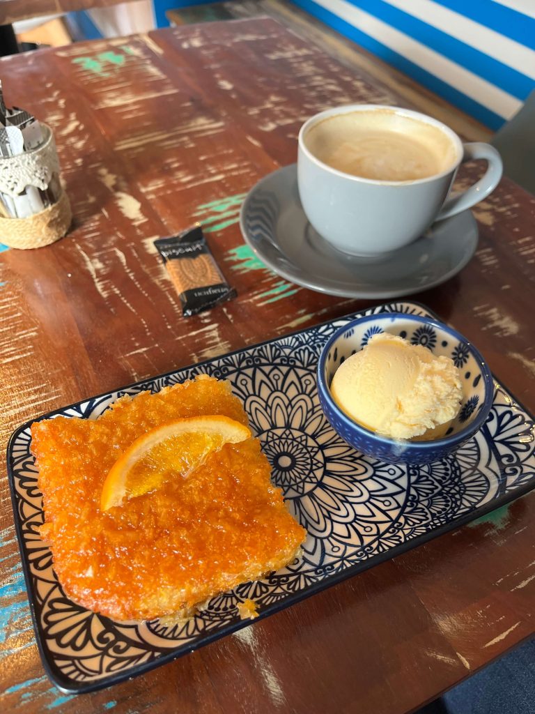 Tea, biscuit, and cake on a table symbolising comfort, reflection, and kindness to yourself.