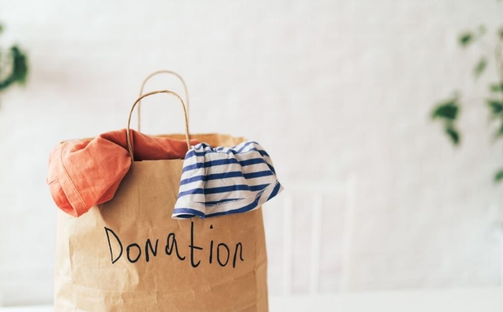 Brown paper bag filled with clothes and belongings ready to be donated to charity